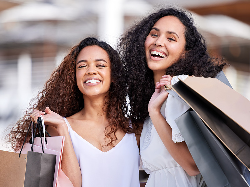 两个年轻女人在城市背景下购物的照片摄影图片下载