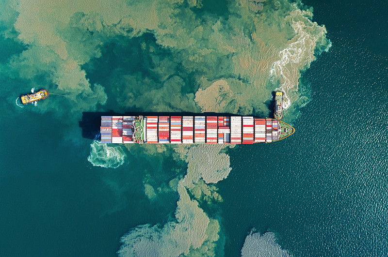 在码头商港推或拉集装箱货轮，用于商业物流、进出口、海运或货物运输。图片下载