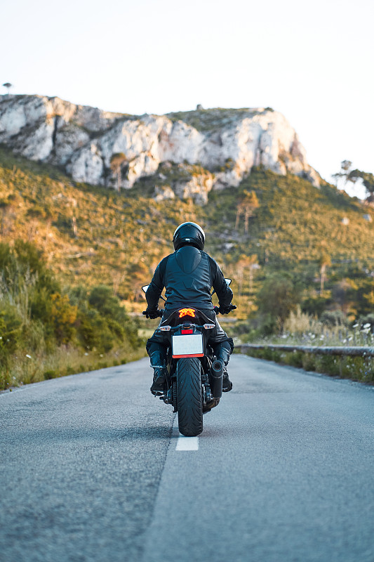 一个不知名的人骑着运动摩托车在大自然图片下载