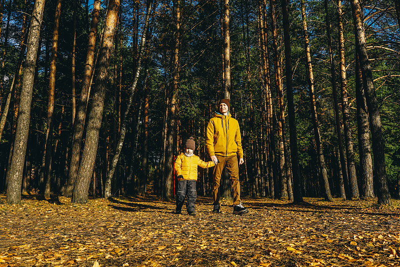 父子俩在秋天的森林里玩耍。图片下载