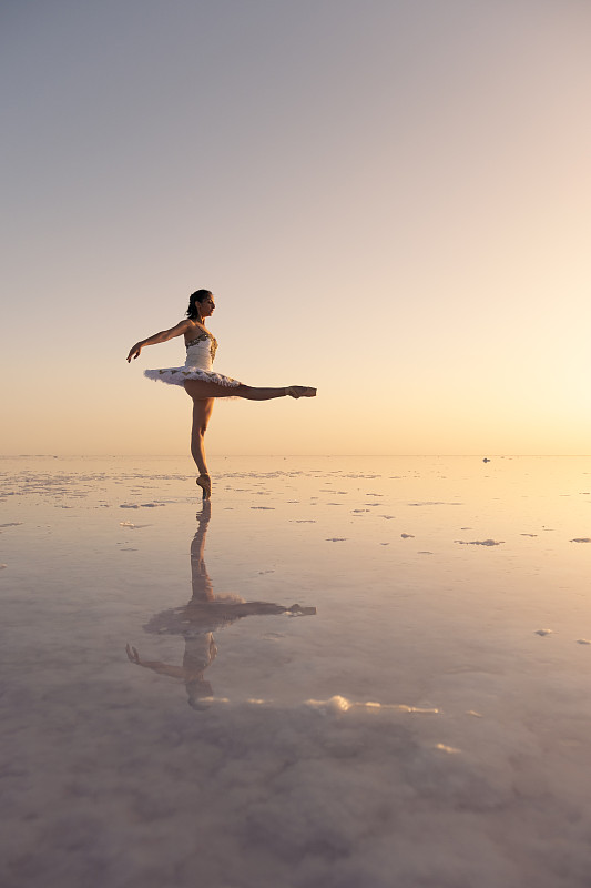 日落时分，芭蕾舞者在图兹湖上跳舞，她在水中的倒影图片下载