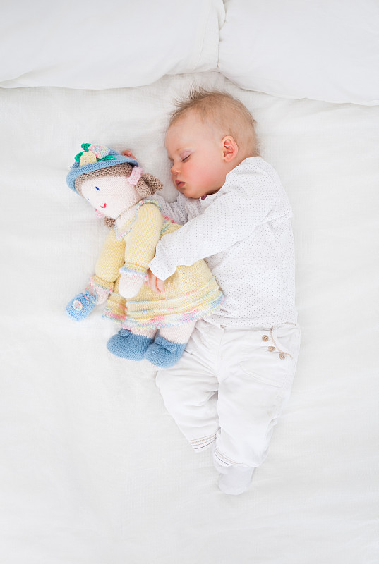 抱着毛绒娃娃睡觉的婴儿图片下载