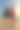 一个穿着红色比基尼，戴着墨镜的女人在金色的日落中沿着海滩散步，背景是山脉。摄影图片