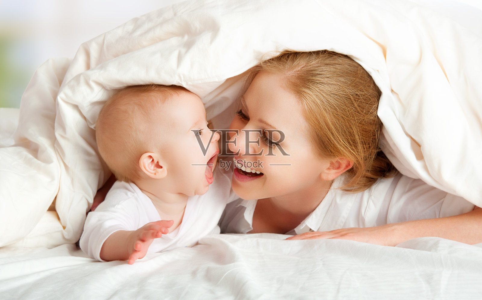 妈妈和毯子下的婴儿肖像照片摄影图片