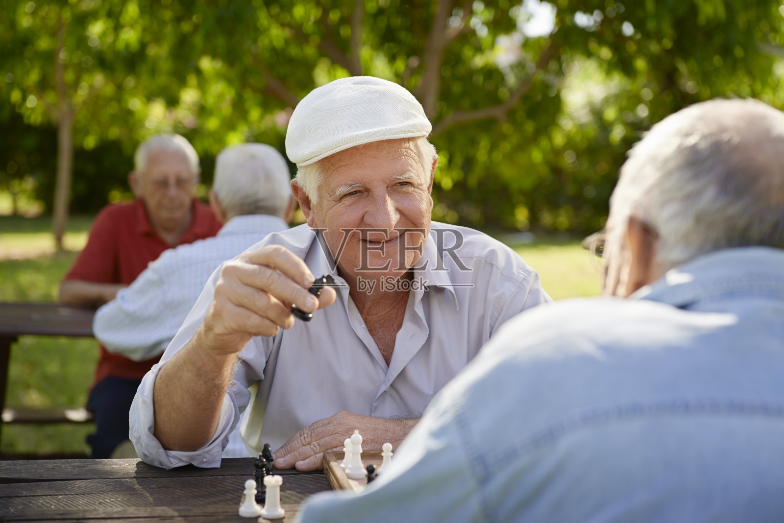老人们在公园里下棋后面有个迷糊的男人照片摄影图片