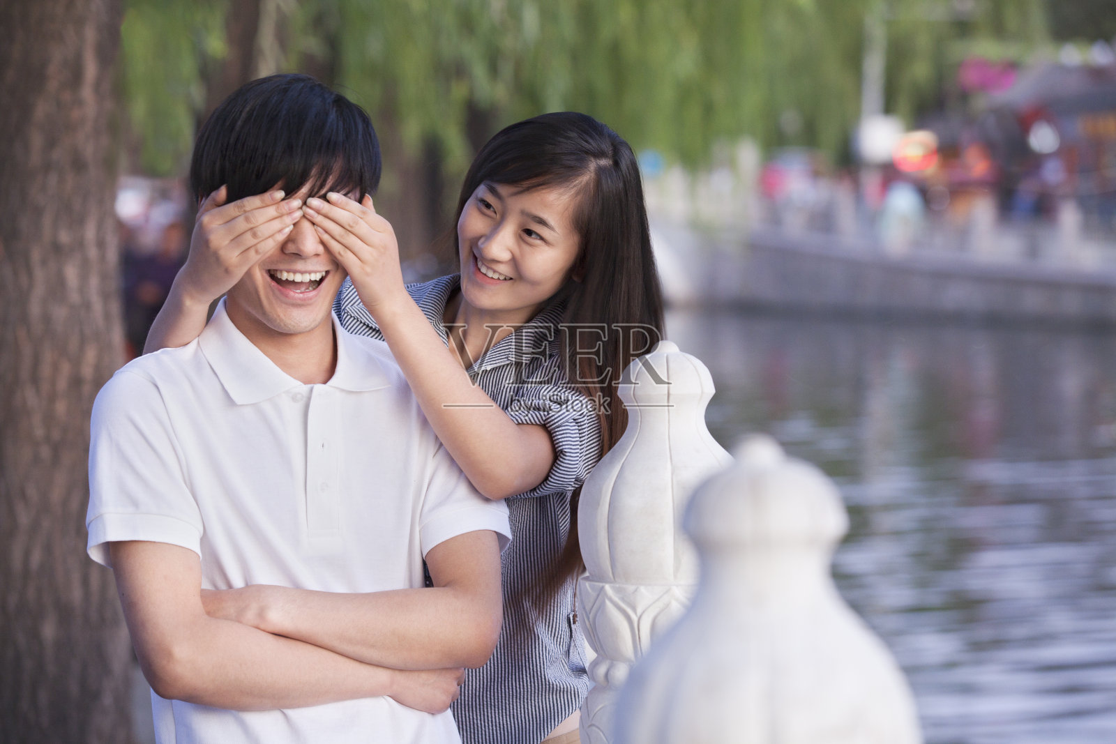 一个女人在湖边遮住男人的眼睛照片摄影图片