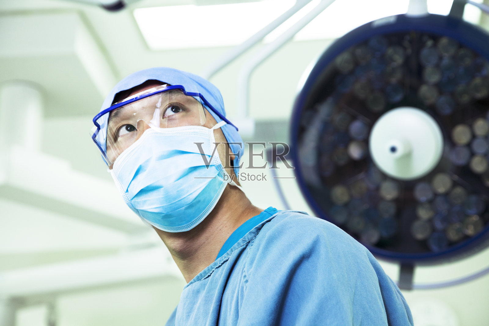 外科医生在手术室戴着外科口罩和眼镜照片摄影图片