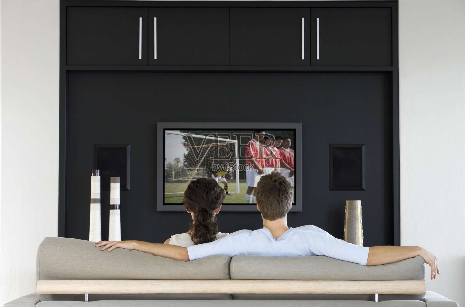 一对夫妇在电视上看足球比赛照片摄影图片