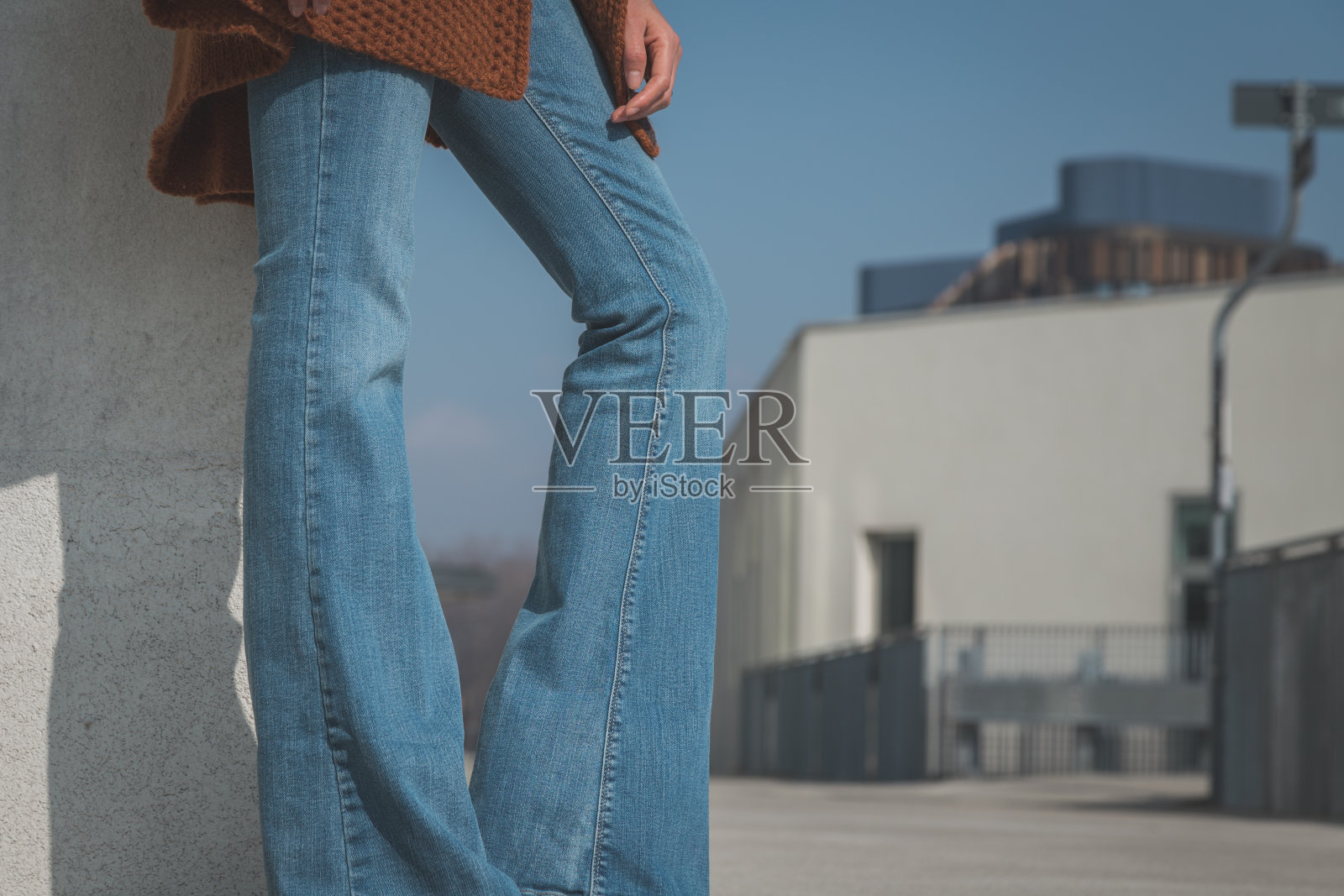 特写一个女人的腿摆姿势在城市的牛仔裤照片摄影图片