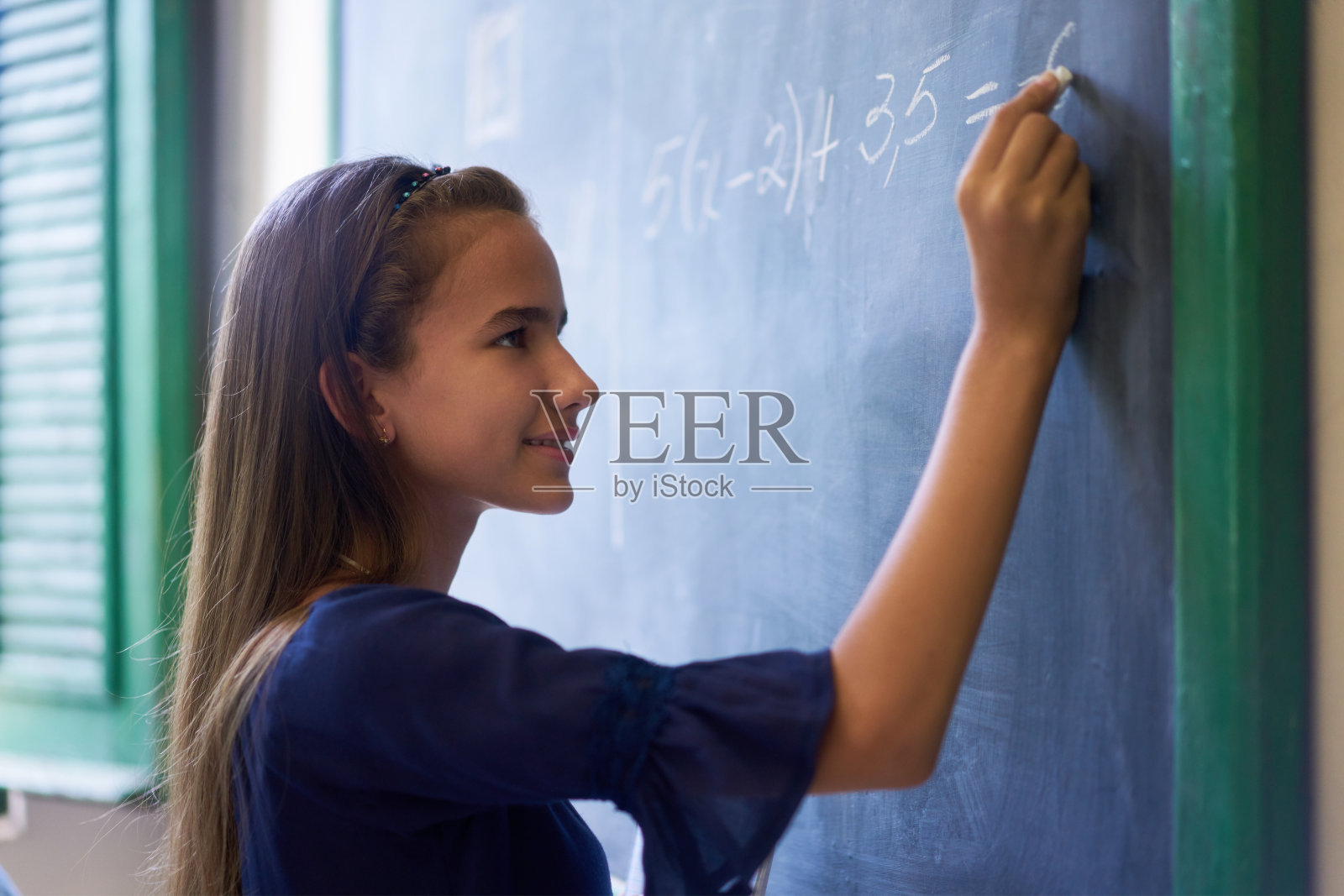 高中课堂上，女孩在黑板上做数学练习照片摄影图片