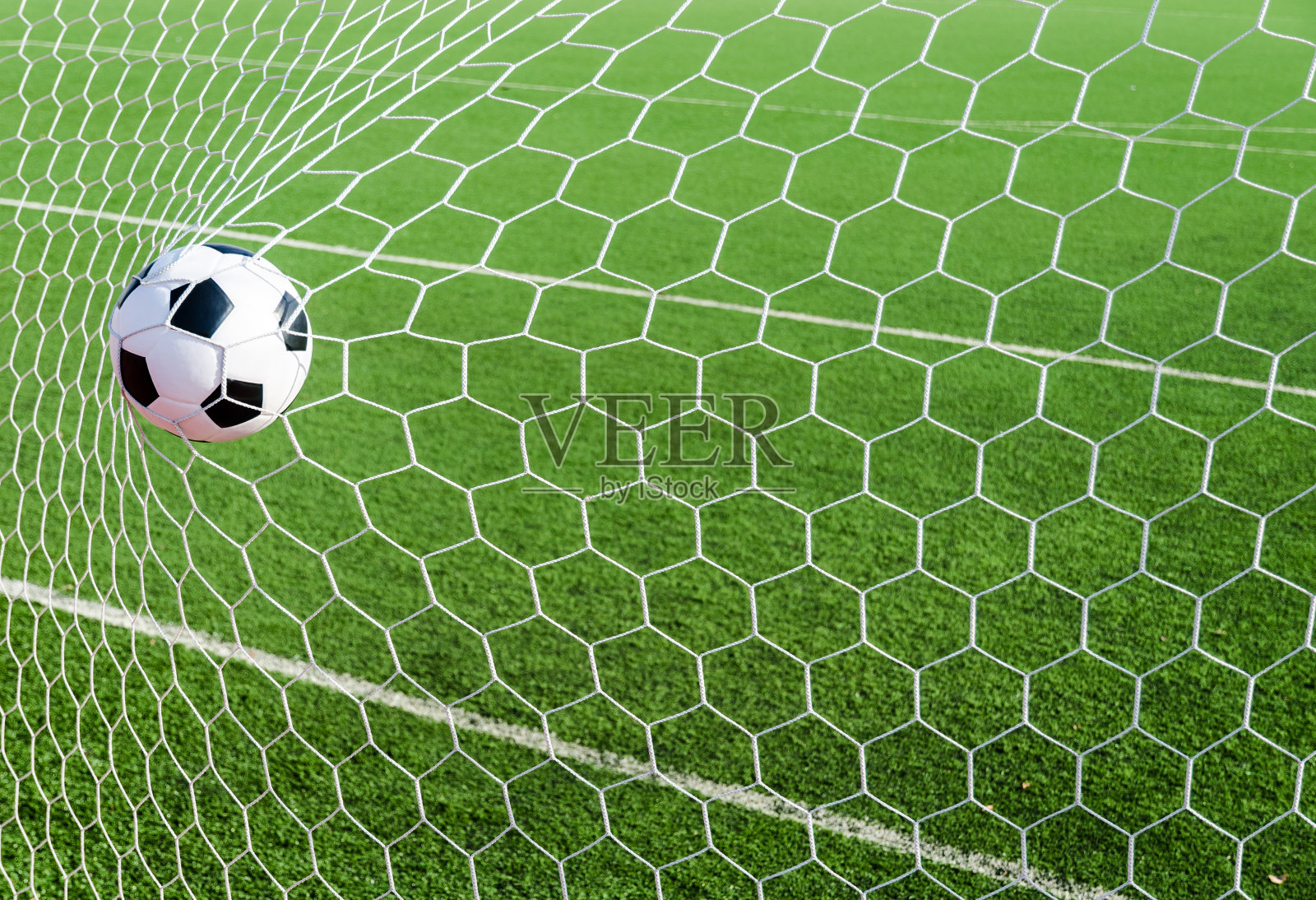 足球足球在球门网与绿色草地的领域。照片摄影图片