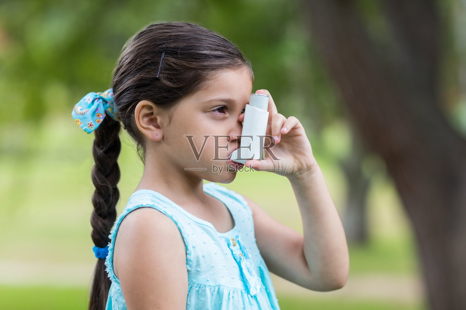 小女孩在用他的吸入器照片摄影图片