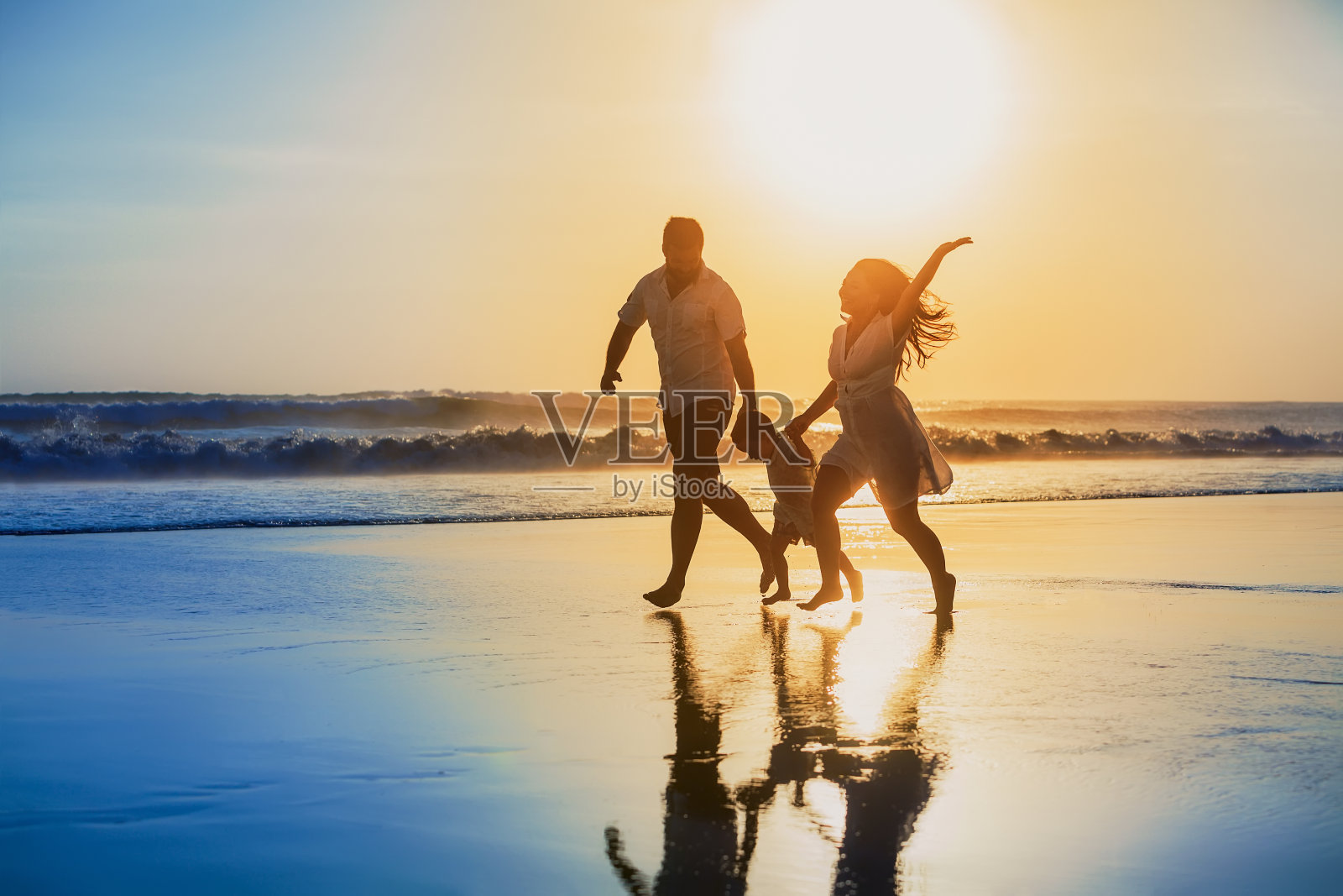 积极的家庭跑步与乐趣在日落海滩照片摄影图片