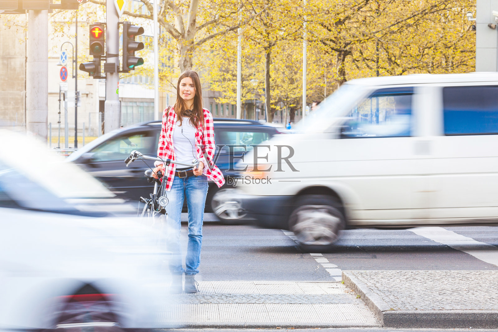 年轻女子骑着自行车等着过马路照片摄影图片