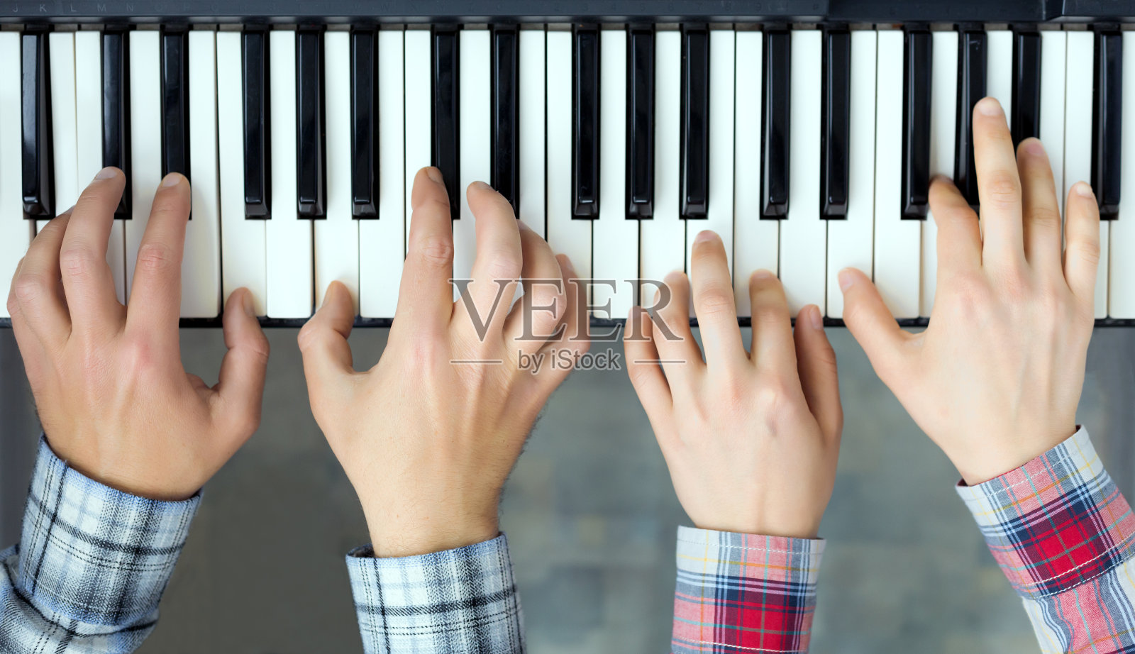 钢琴键盘俯视图手的男人和女人的演奏照片摄影图片