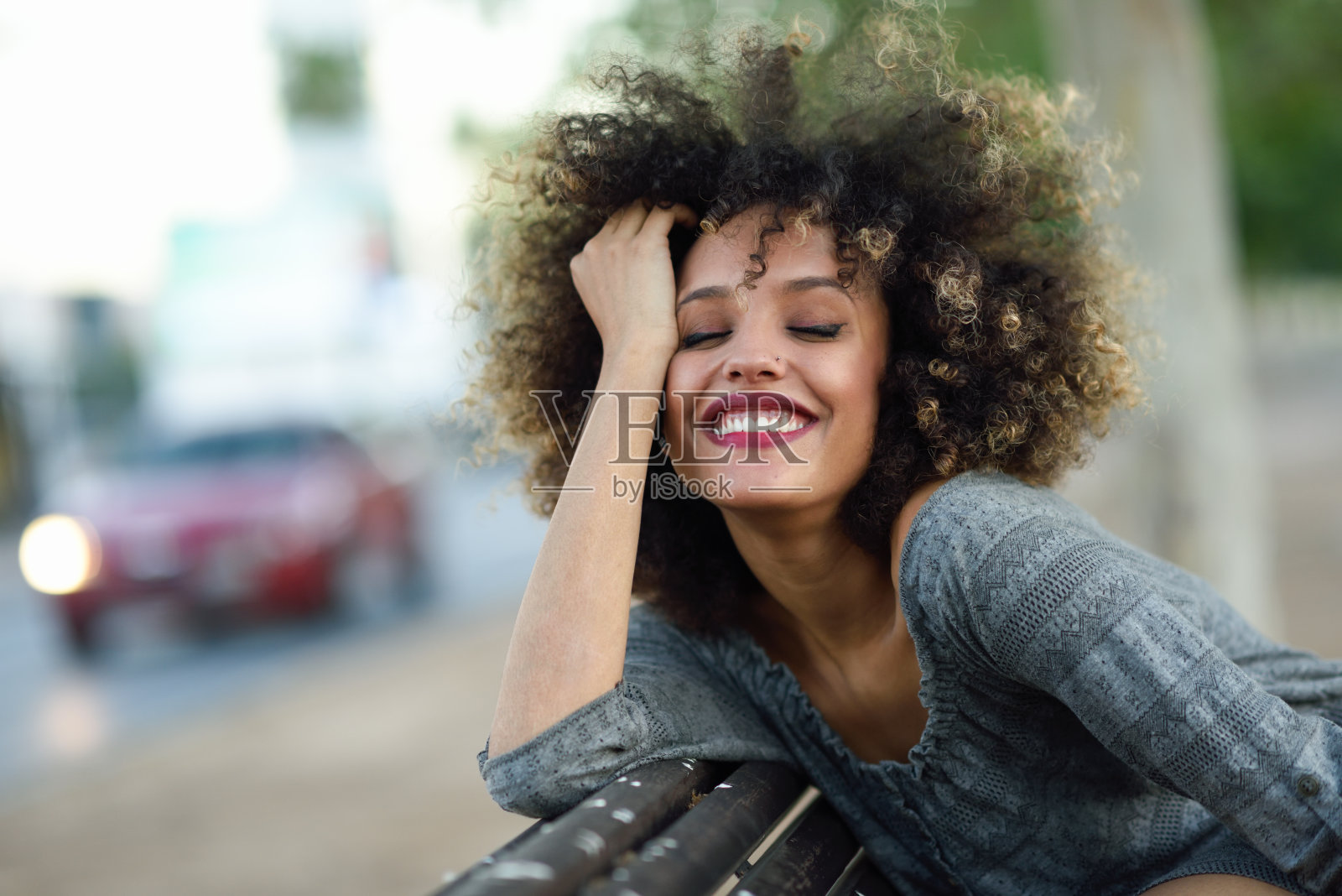 年轻的黑人妇女与非洲发型微笑在城市背景照片摄影图片