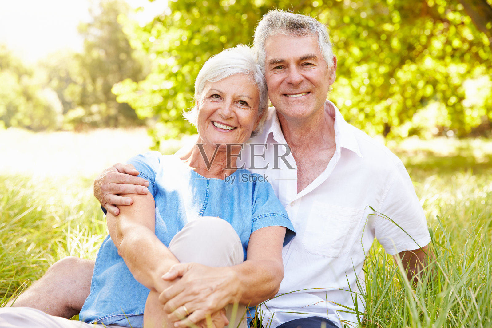 老夫妇坐在草地上一起放松照片摄影图片