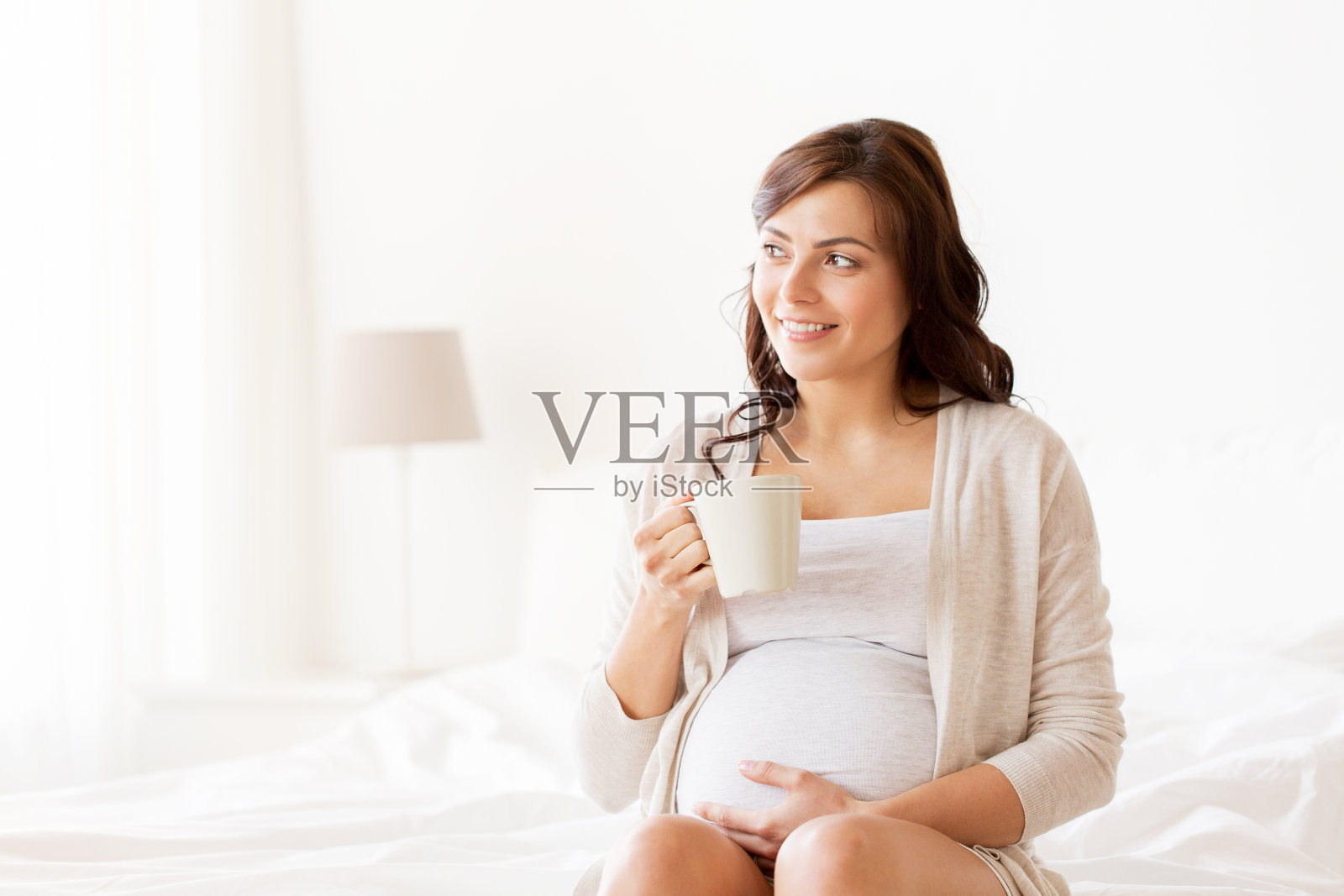 开心孕妇在家用杯子喝茶照片摄影图片