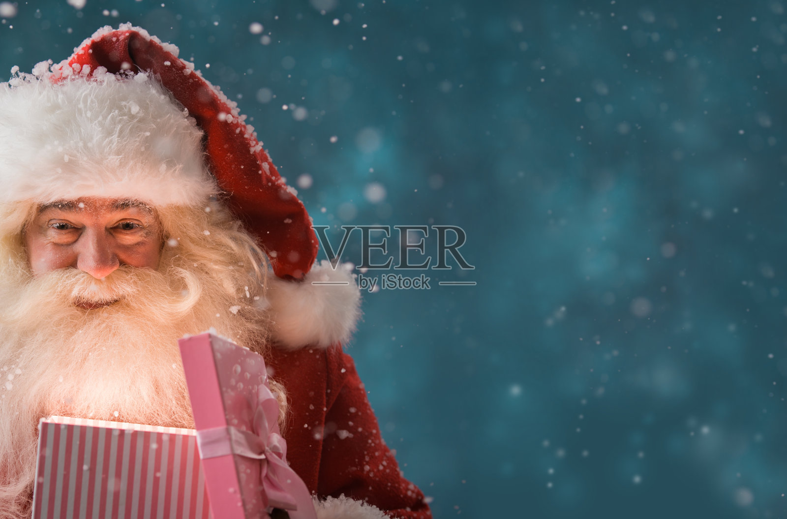 在北极，圣诞老人在户外打开礼盒照片摄影图片