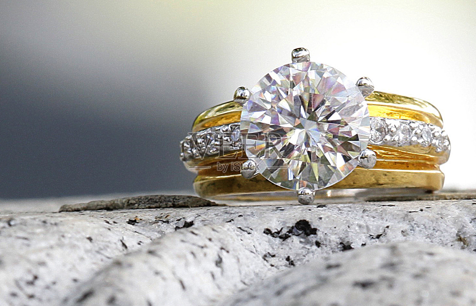 漂亮的钻石戒指坐在花岗岩上照片摄影图片