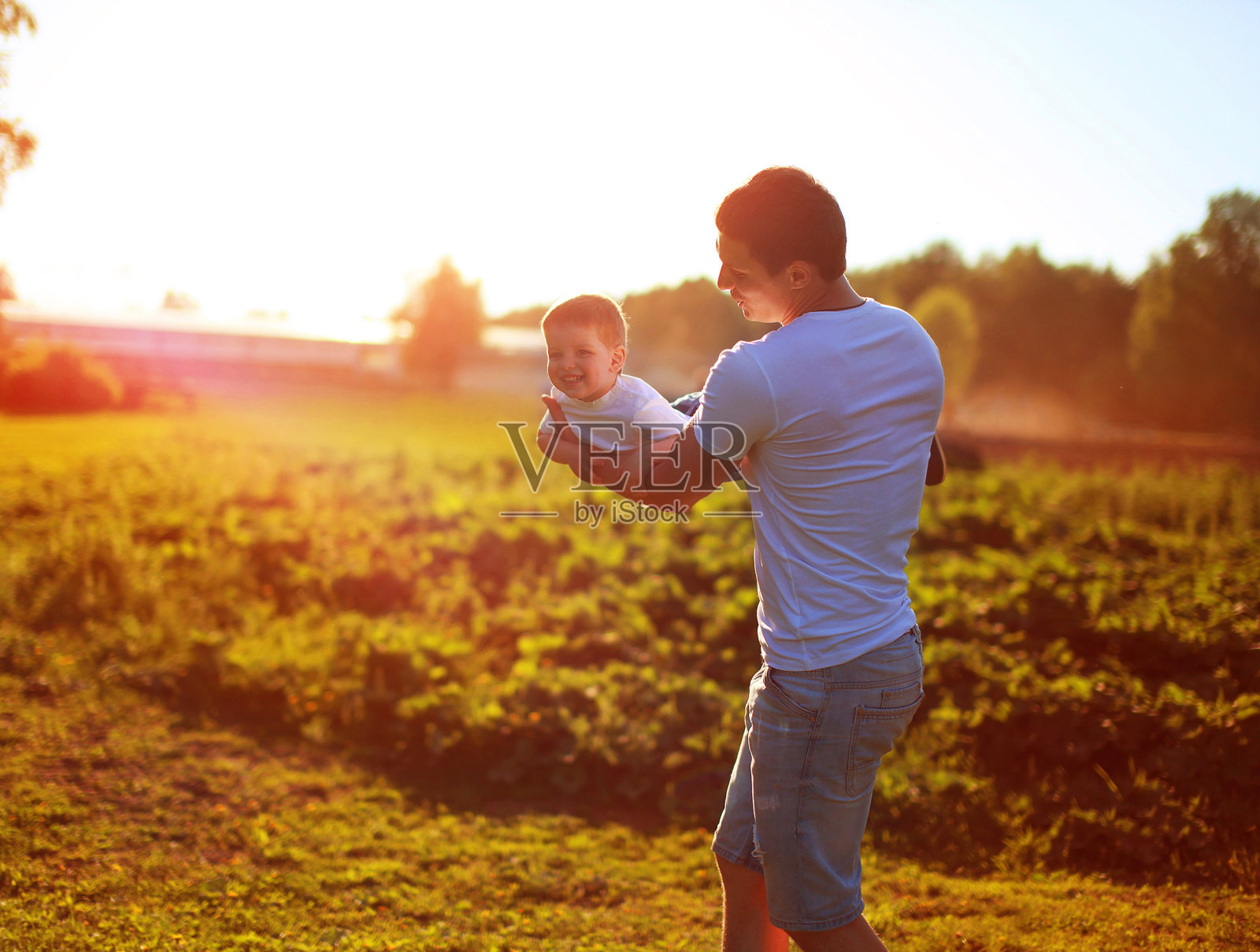 快乐的父亲，孩子，儿子玩在阳光灿烂的傍晚日落照片摄影图片