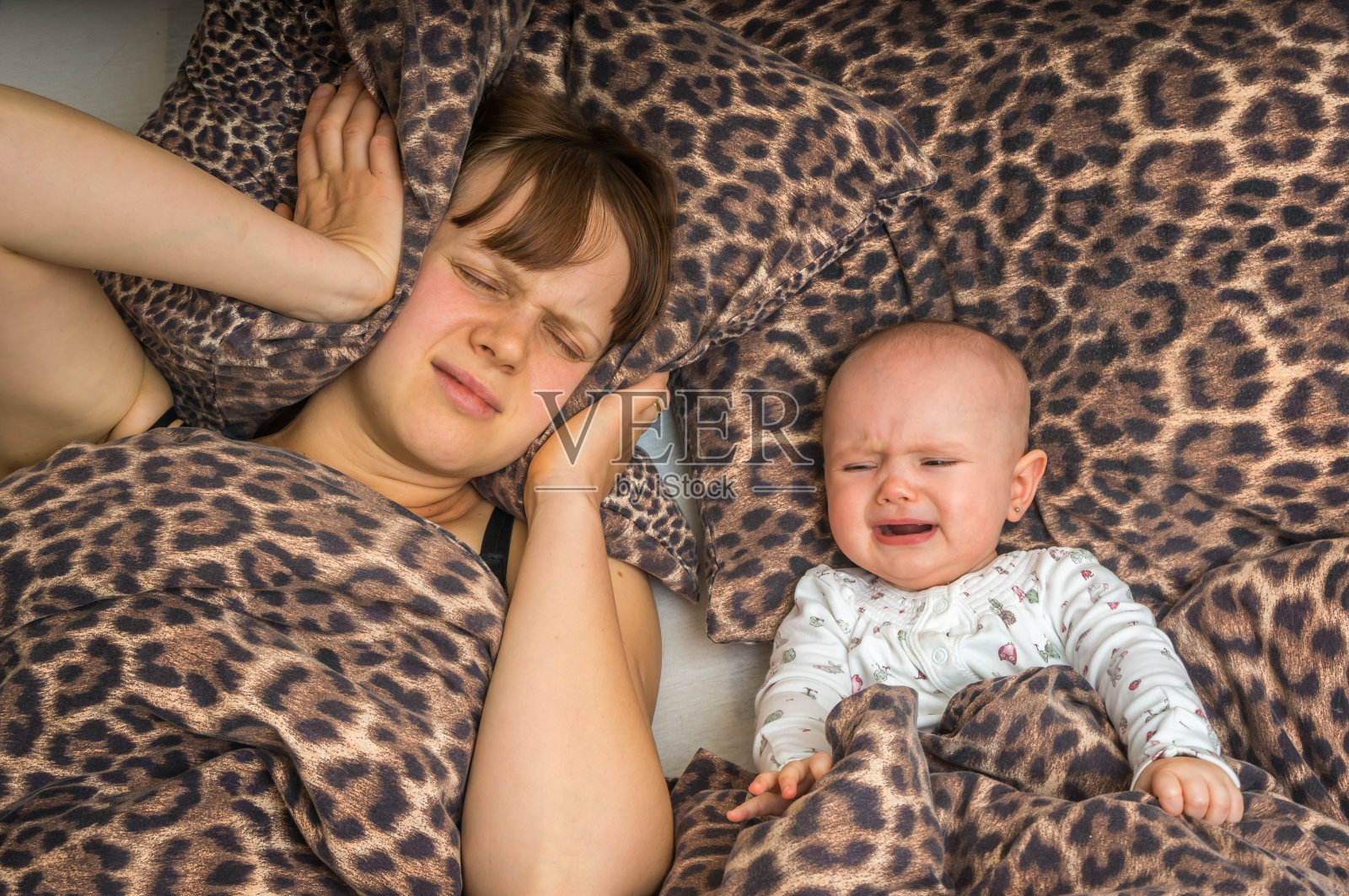 疲惫的母亲睡不着，因为她的孩子在哭照片摄影图片