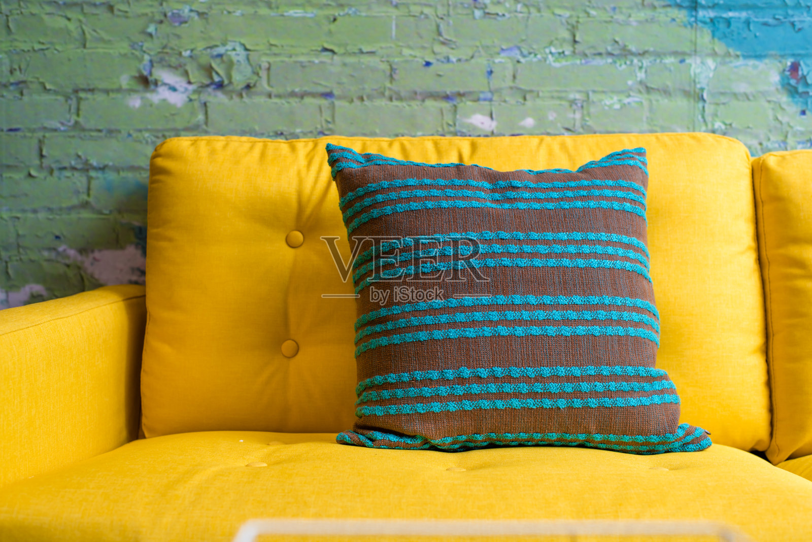 鲜黄色沙发上的绿色条纹枕头照片摄影图片