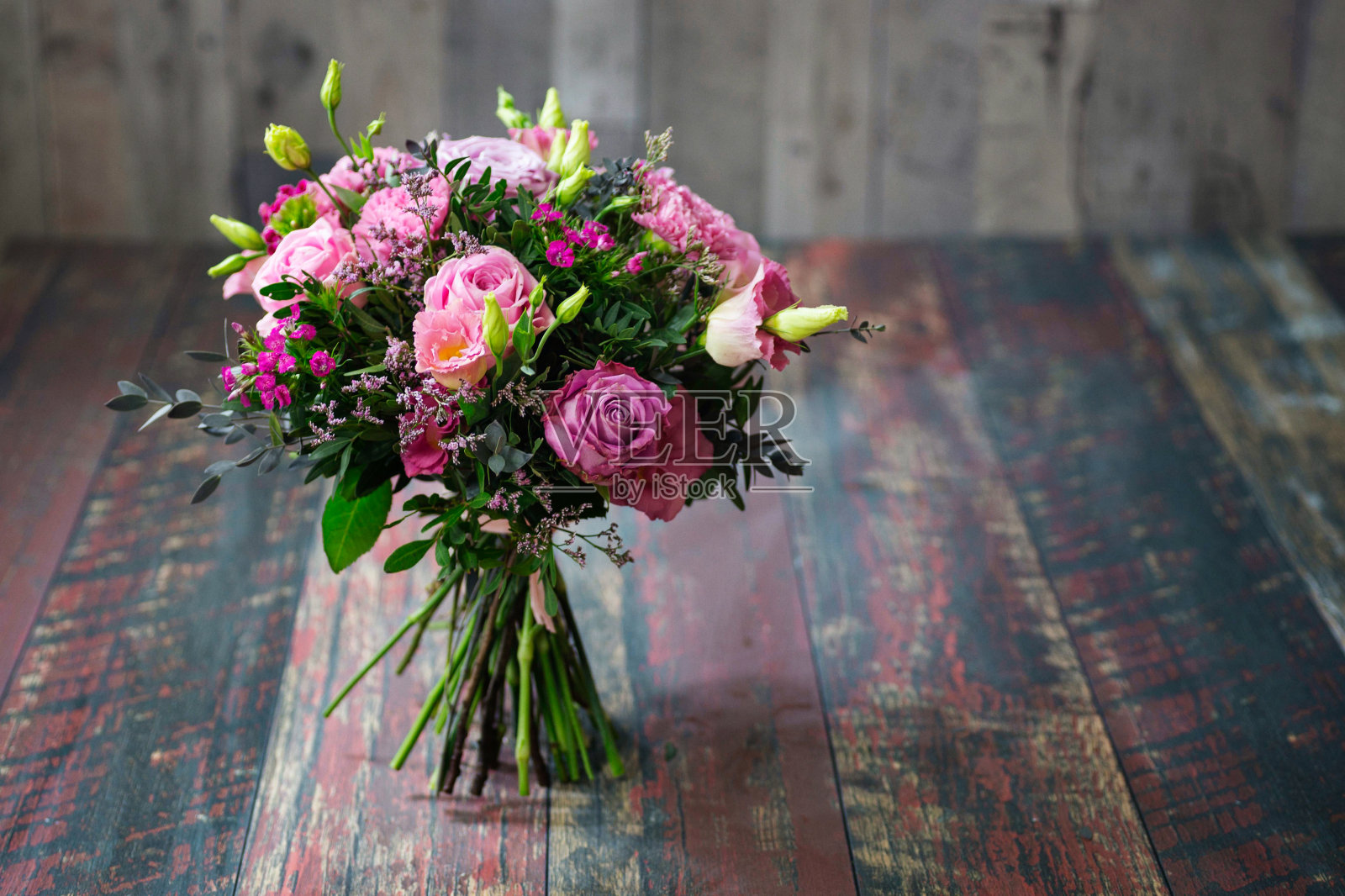 带有粉色玫瑰和洋桔梗花的乡村婚礼花束。照片摄影图片