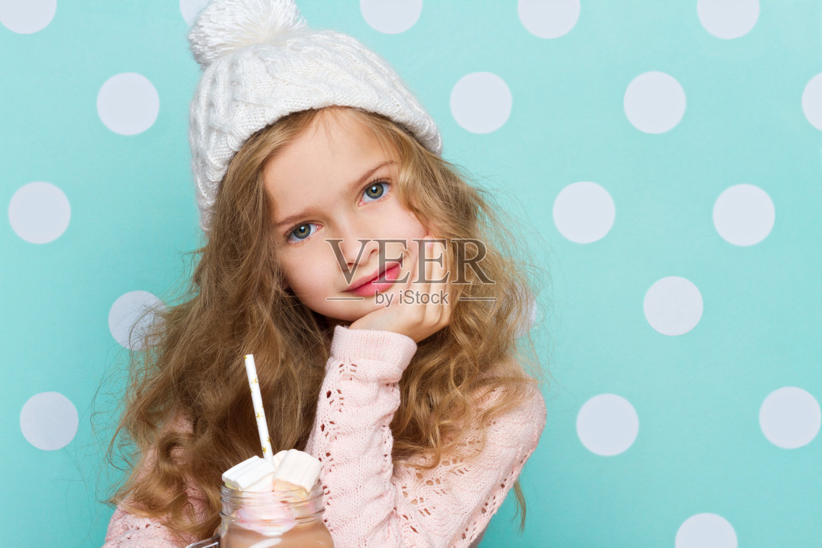 戴着帽子喝着热巧克力和棉花糖的年轻女孩照片摄影图片