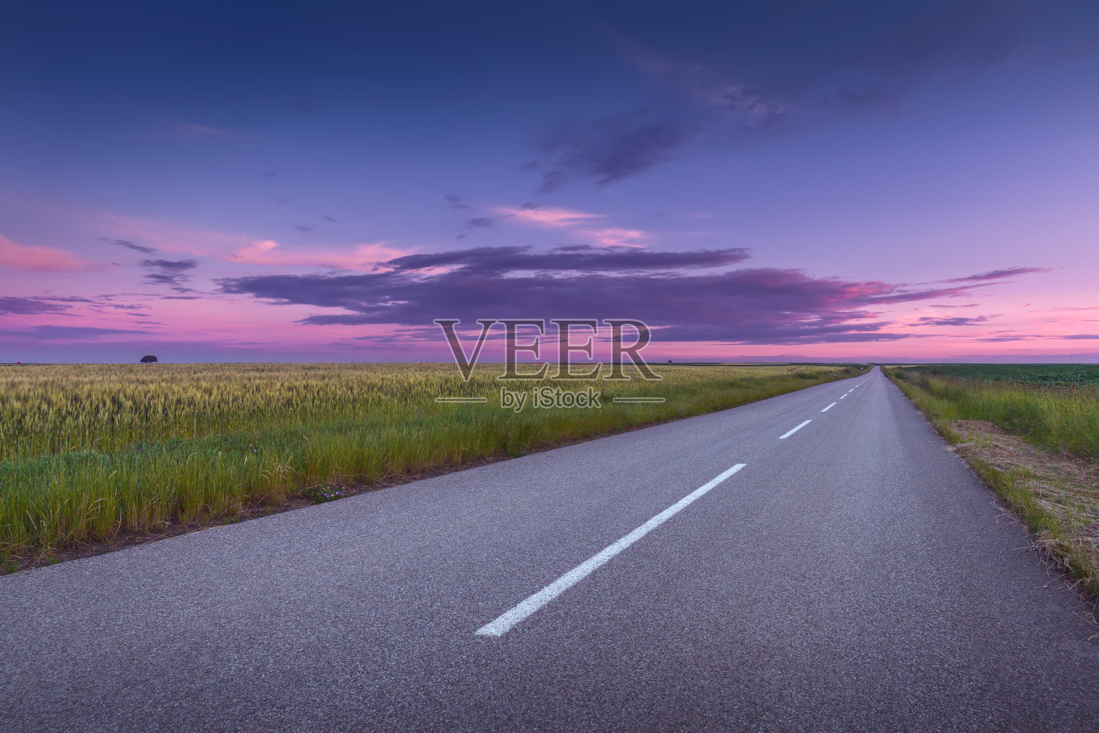 在美丽的夕阳下行驶在宽阔的柏油路上照片摄影图片