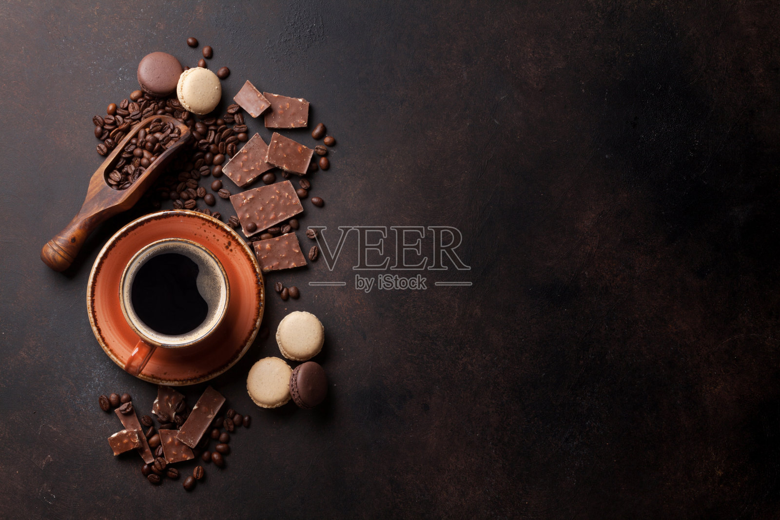 咖啡杯，巧克力和杏仁饼干放在旧餐桌上照片摄影图片
