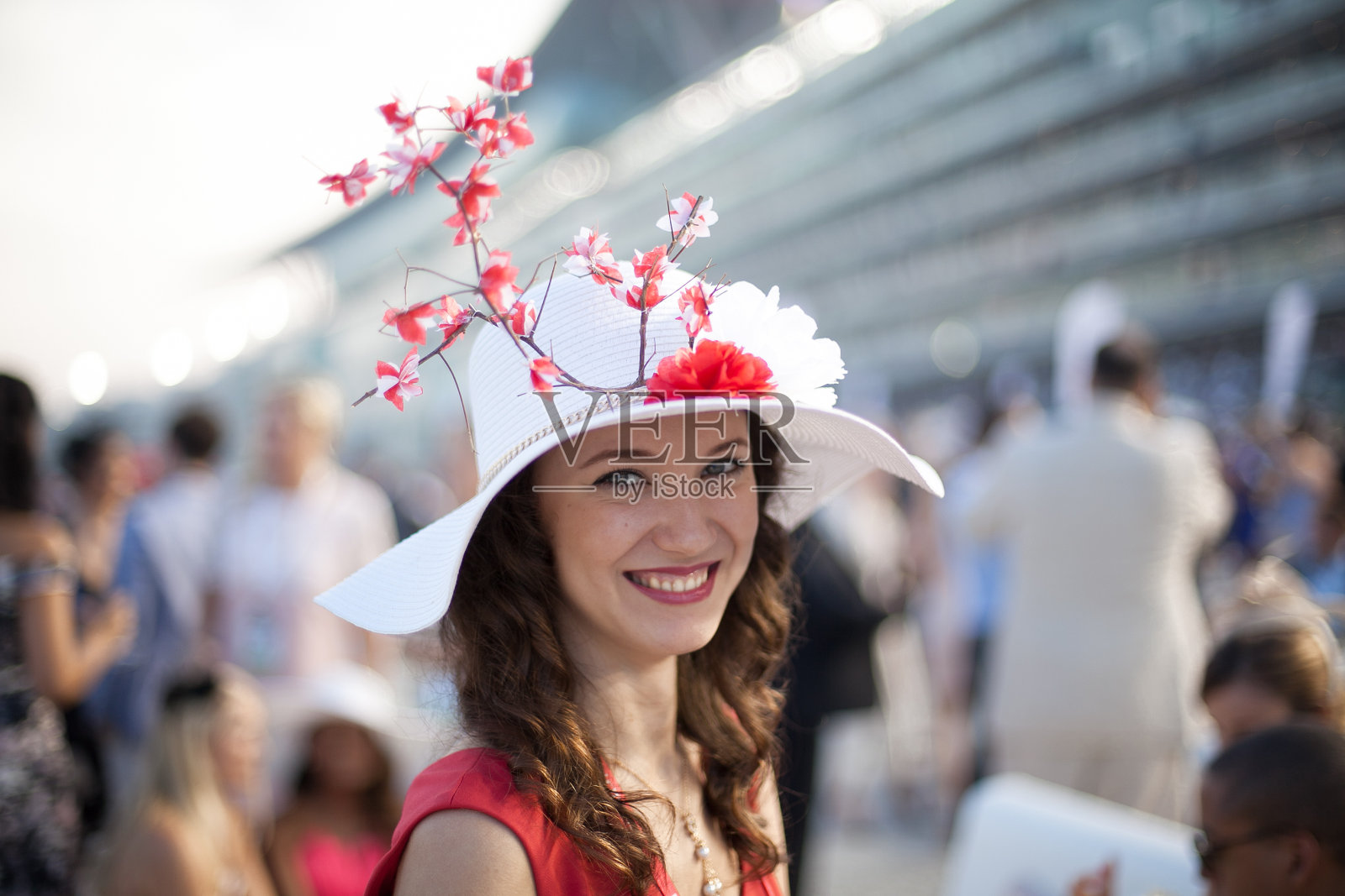 美丽的女孩戴着樱花帽在赛马照片摄影图片