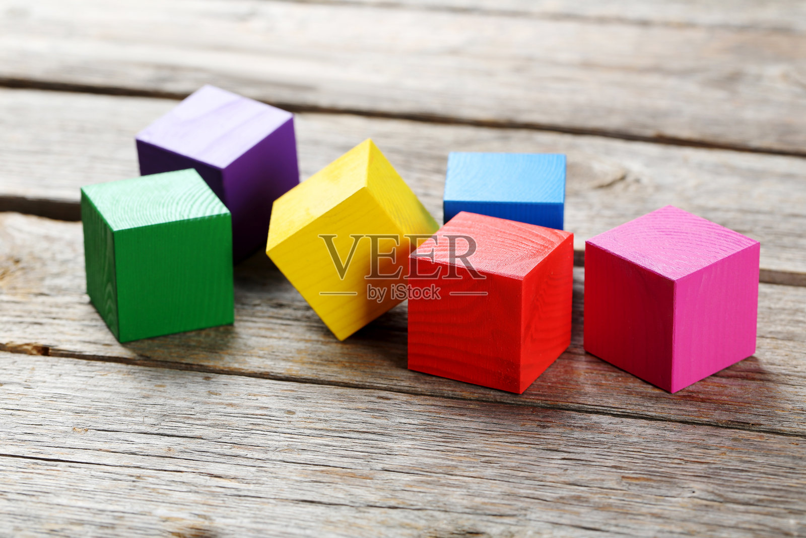 彩色的木制立方体玩具在灰色的木制背景上照片摄影图片