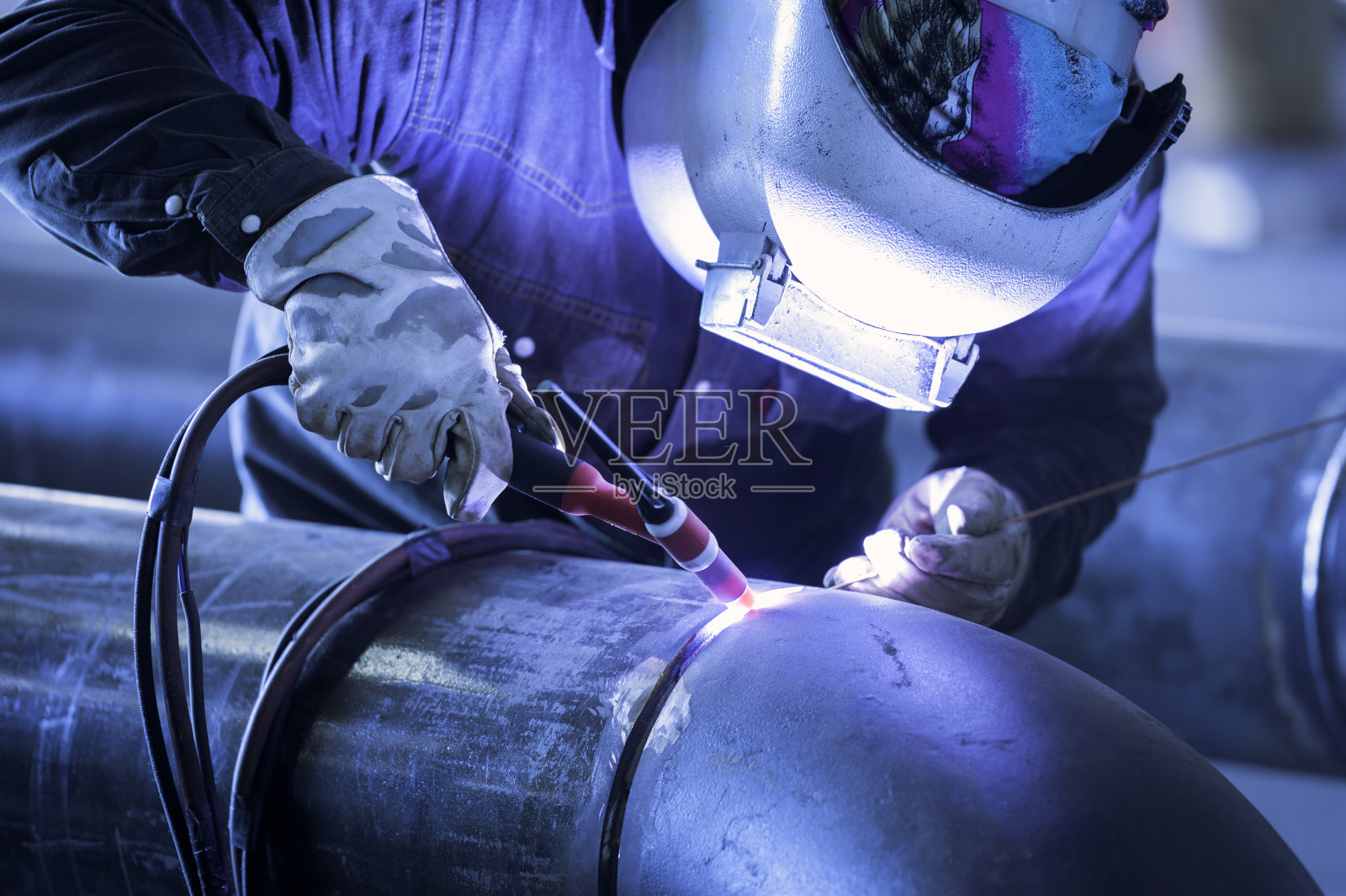 使用tig焊机焊接金属管道的工人照片摄影图片