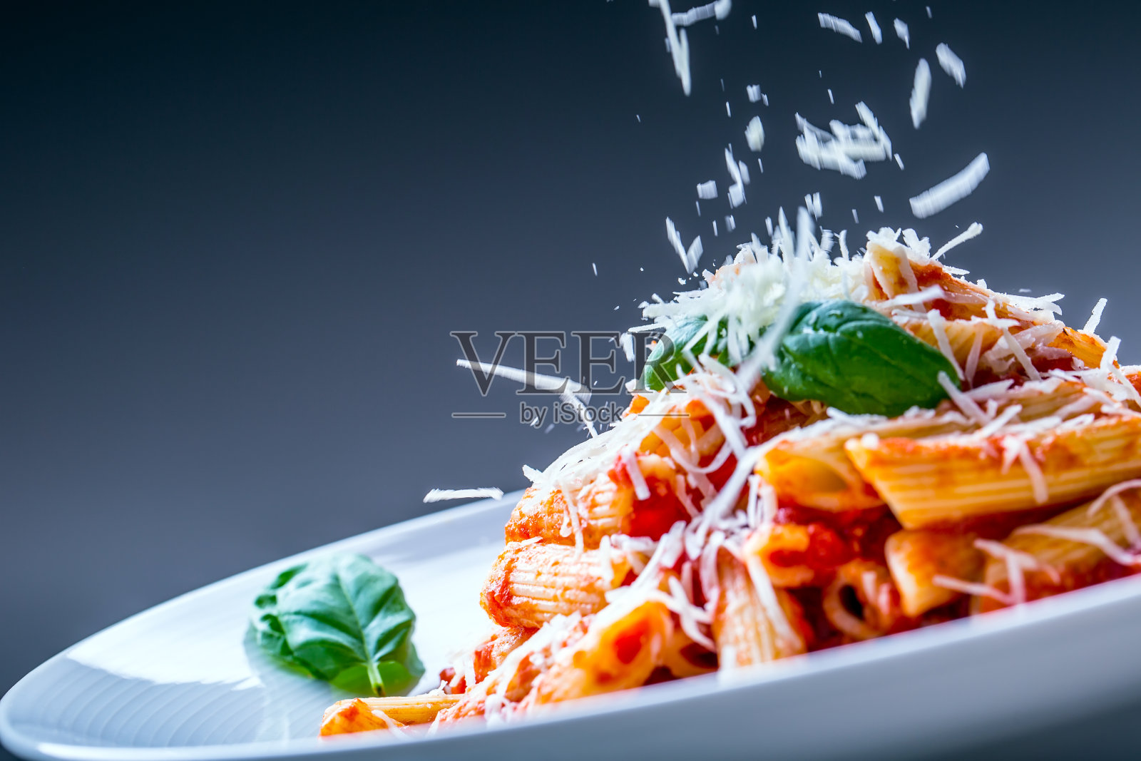 意大利通心粉，番茄肉酱，帕尔马干酪和罗勒。照片摄影图片