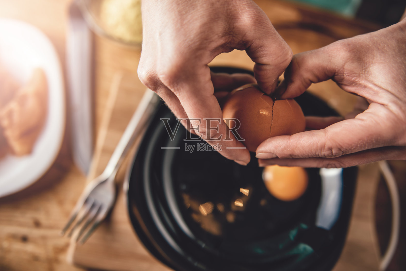 女人在做饭，把鸡蛋打到盘子里照片摄影图片
