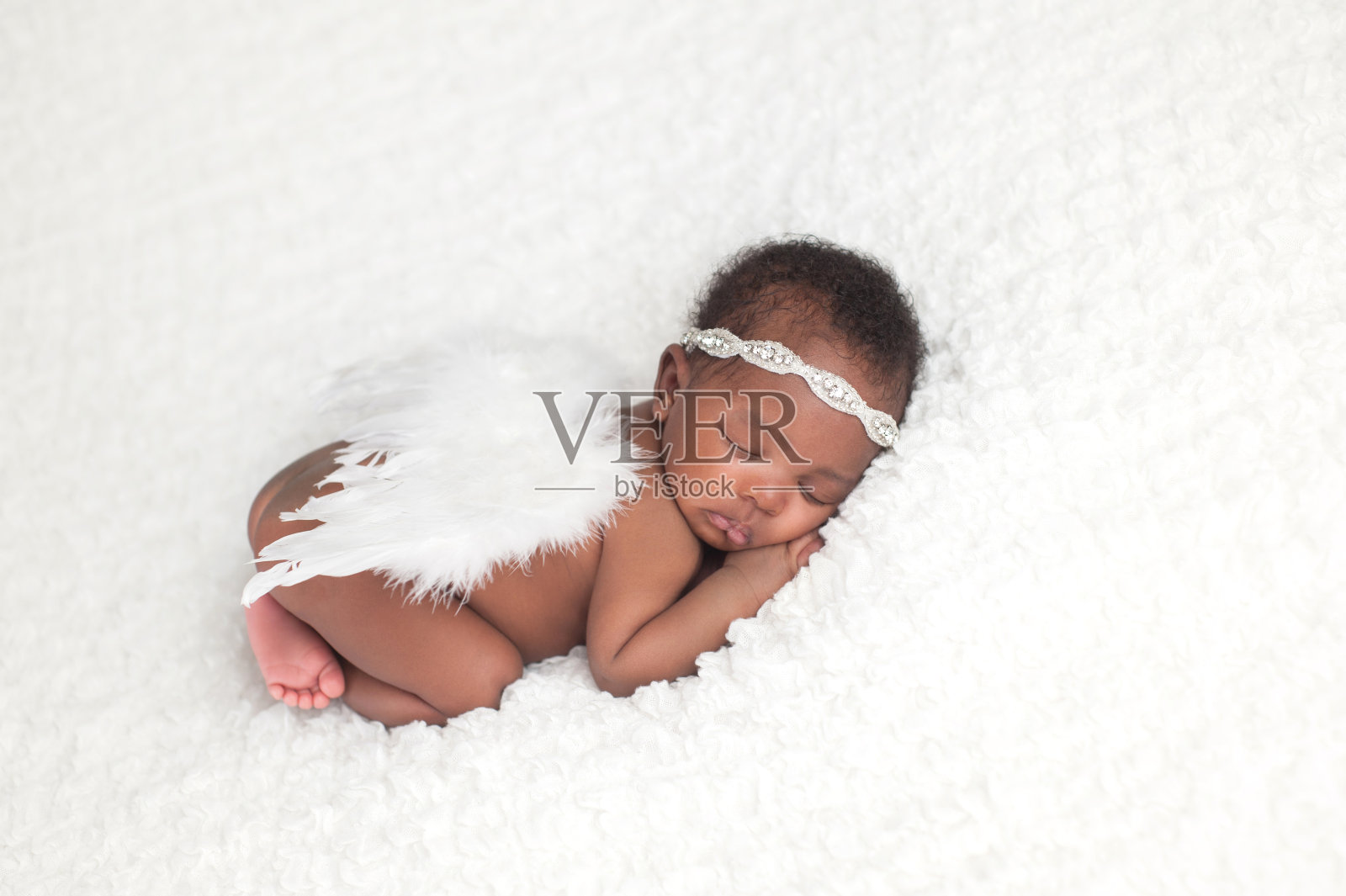 新生女婴戴着天使翅膀照片摄影图片