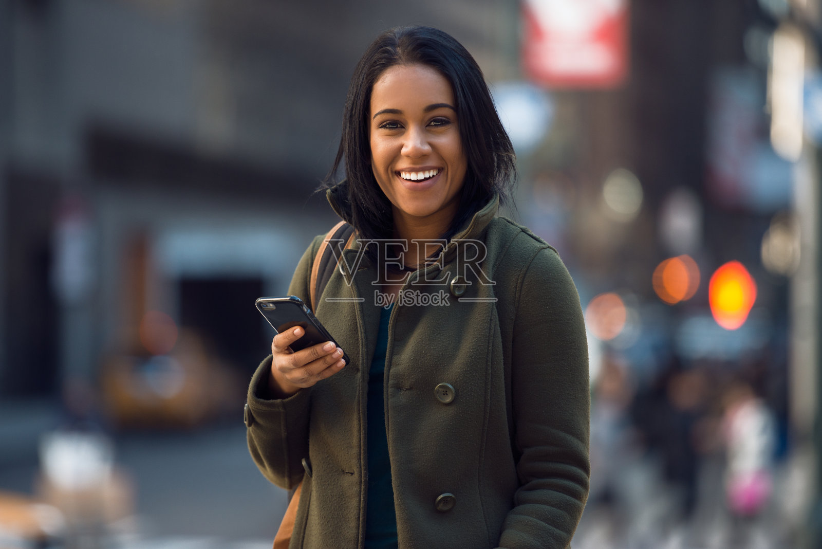 美丽年轻快乐的拉丁女人在手机上发短信照片摄影图片