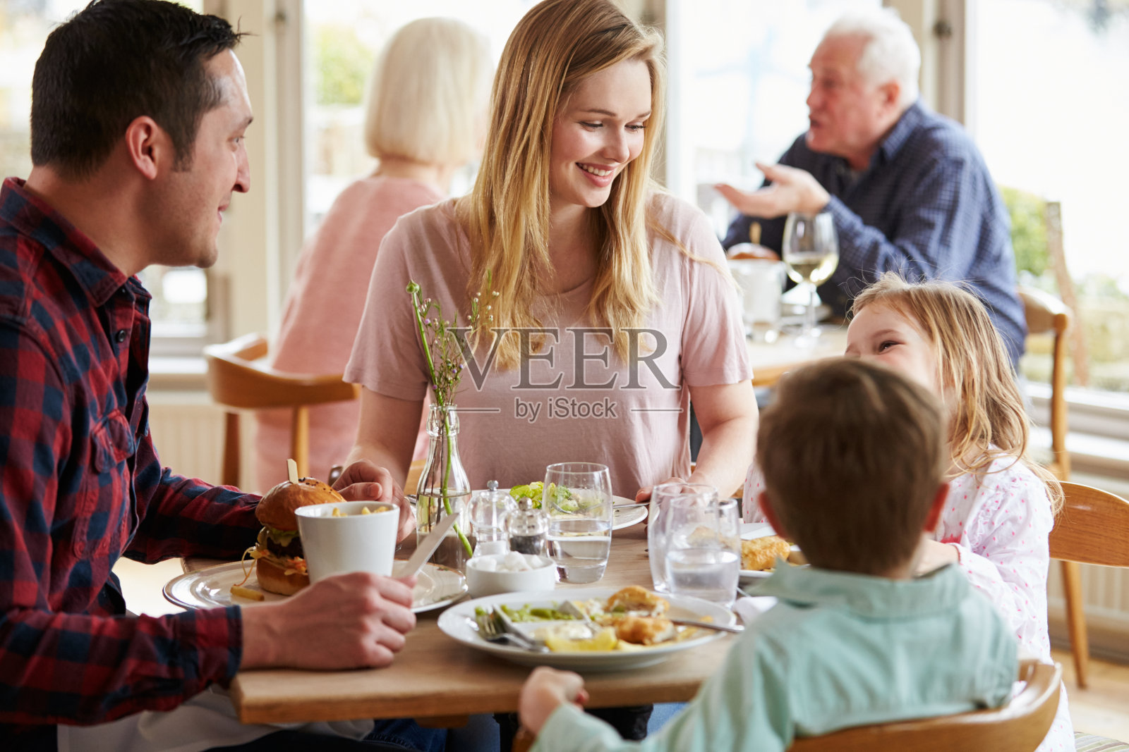 一家人一起在餐厅用餐照片摄影图片
