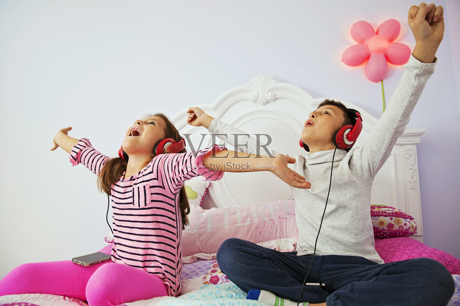 快乐的男孩和女孩通过耳机听音乐照片摄影图片