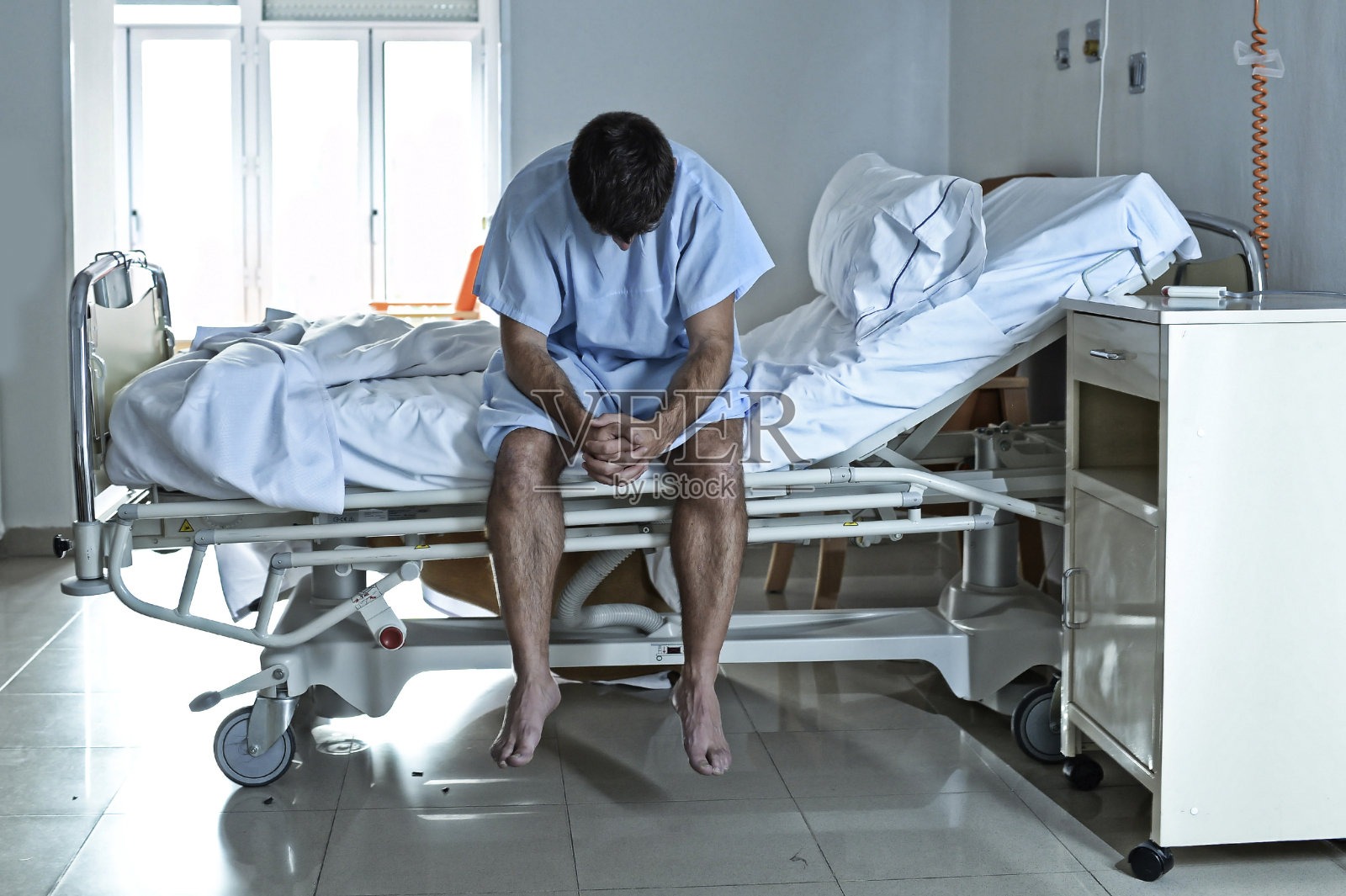 绝望的病人独自躺在病床上，悲伤而沮丧照片摄影图片