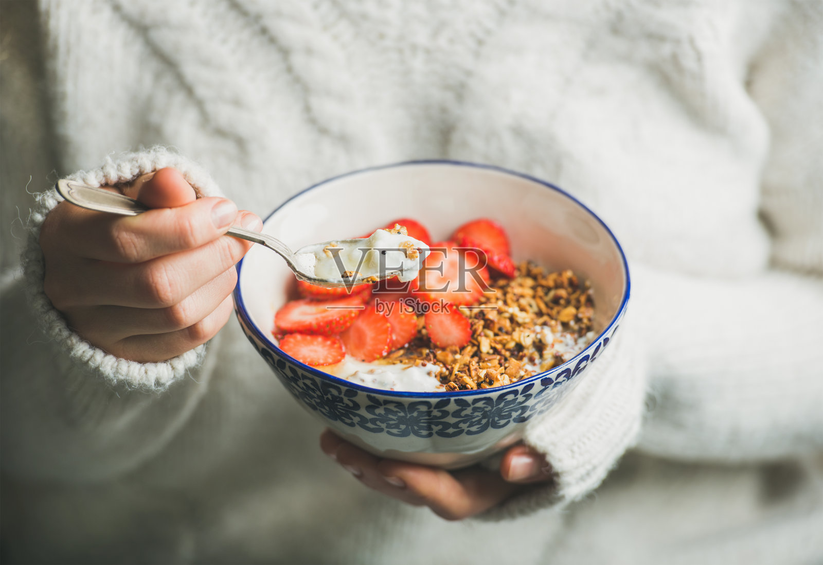 健康早餐酸奶，格兰诺拉麦片，女人手里拿着草莓碗照片摄影图片