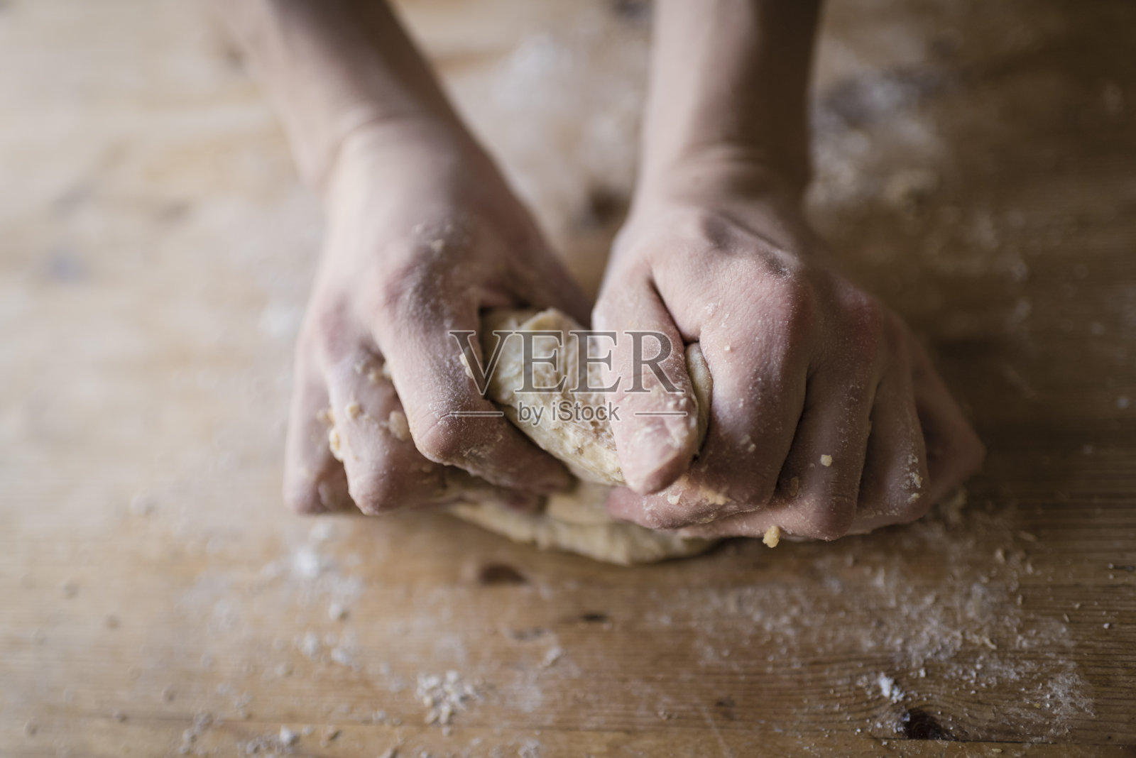 面包师的两只强壮的手揉着自制的面团照片摄影图片