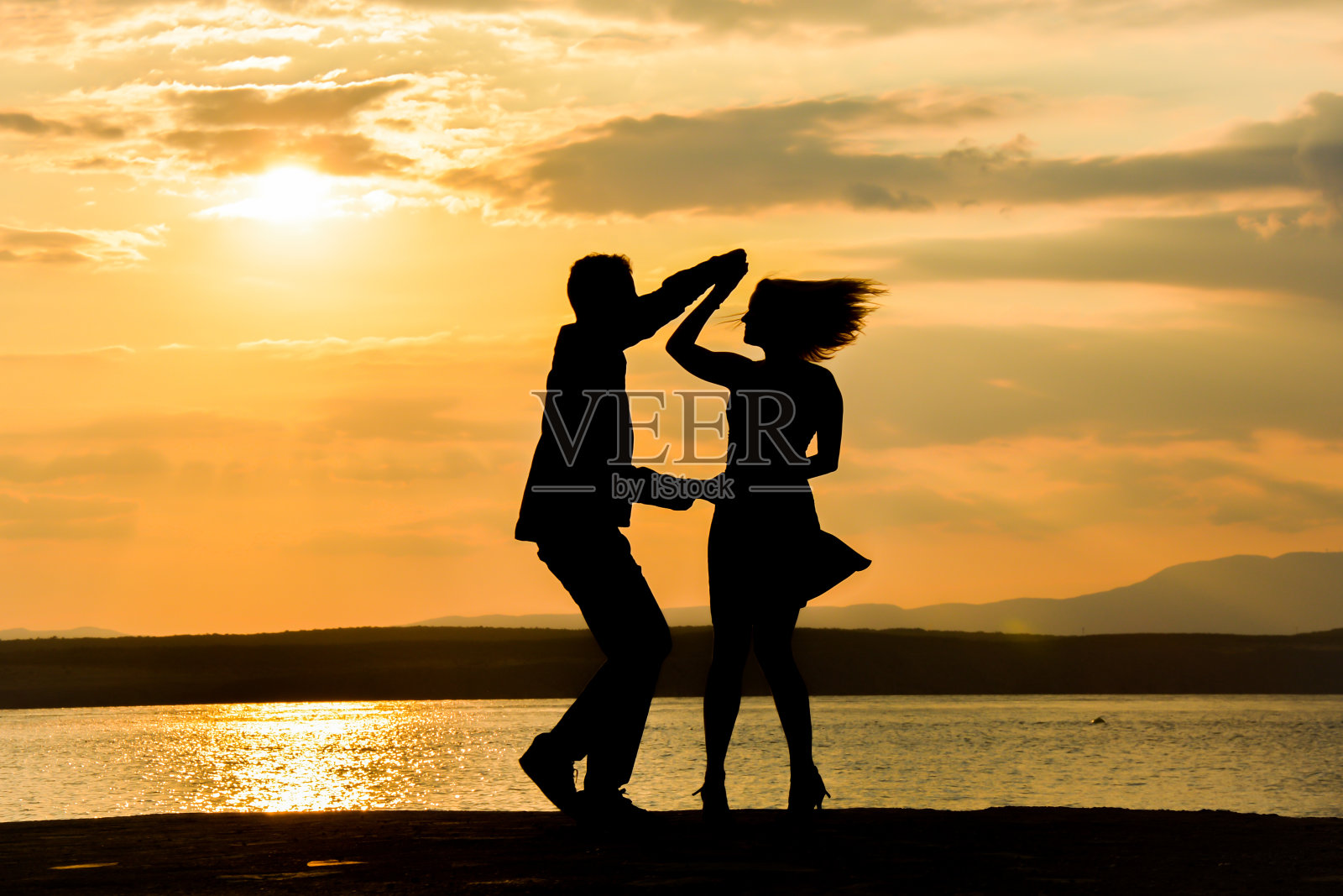 情侣在夕阳下跳萨尔萨舞照片摄影图片
