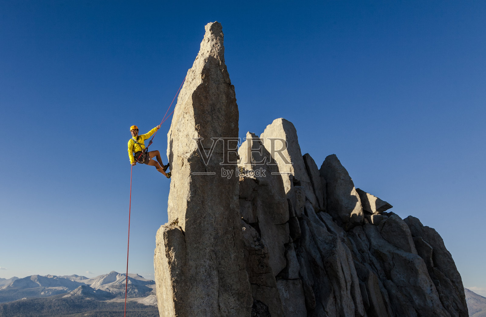 攀登者从山顶用绳索下降。照片摄影图片