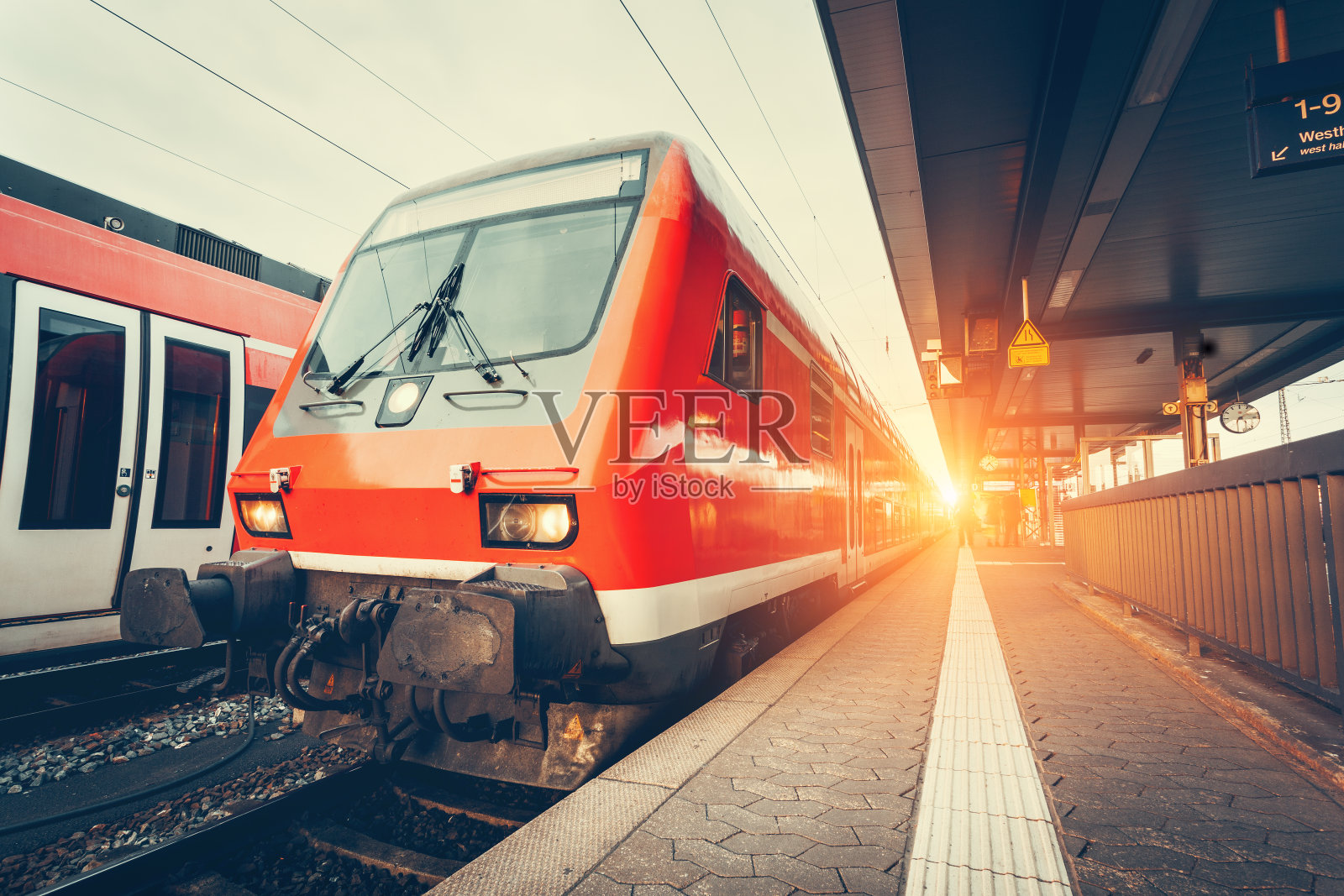 现代高速红色通勤列车在多彩的日落照片摄影图片