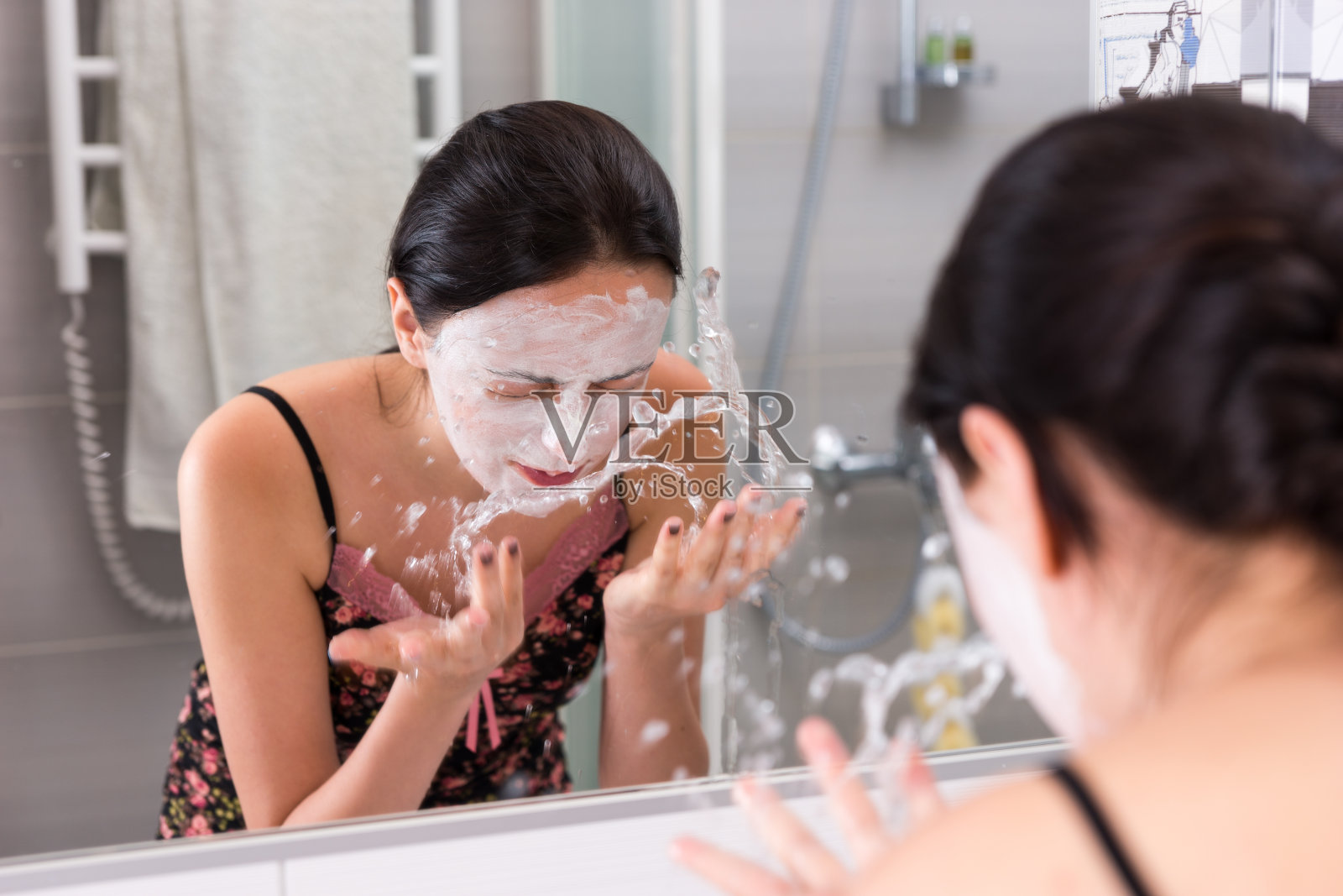 一个女人用化妆面膜往脸上喷水照片摄影图片
