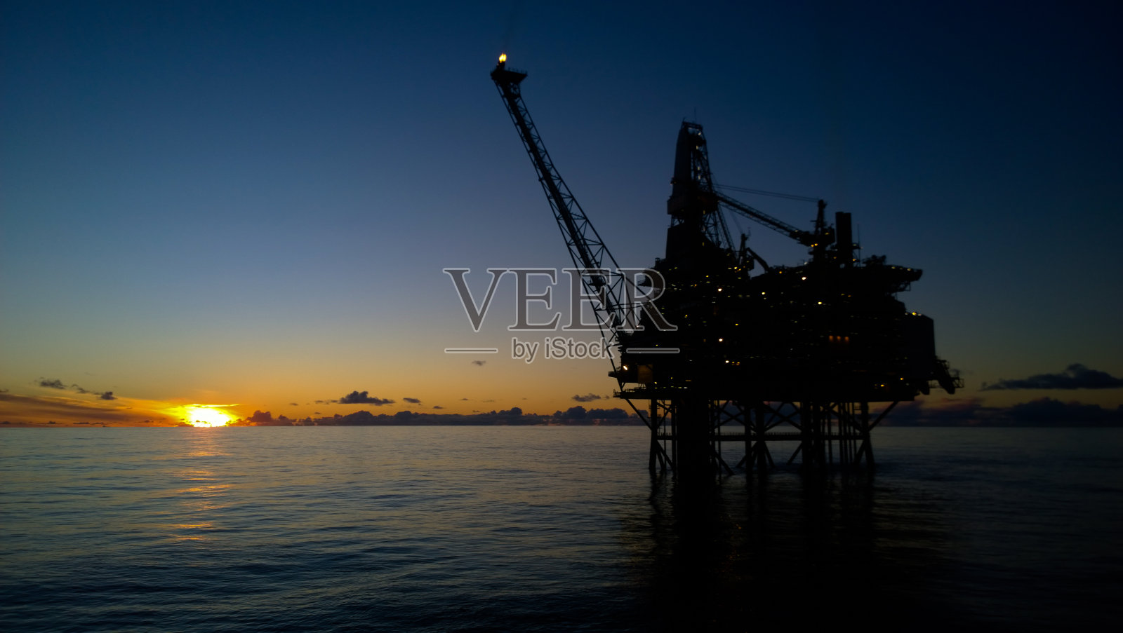 夕阳中的石油钻塔照片摄影图片