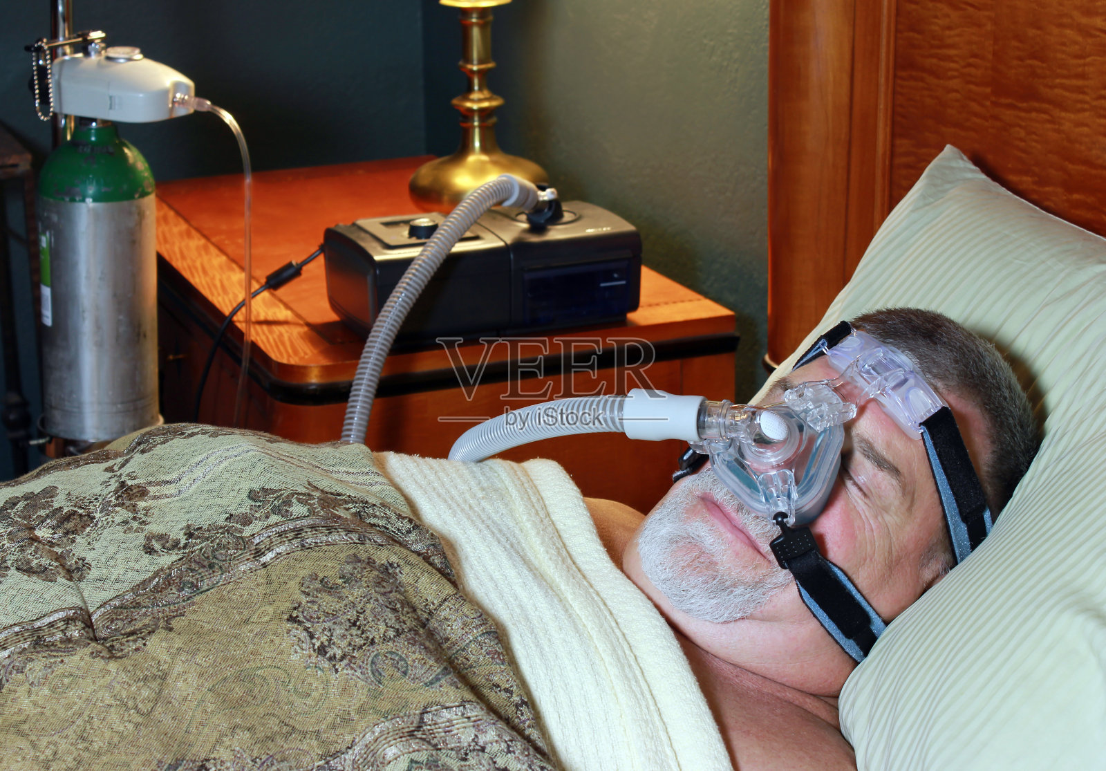 老年男子在CPAP和氧气下睡觉照片摄影图片