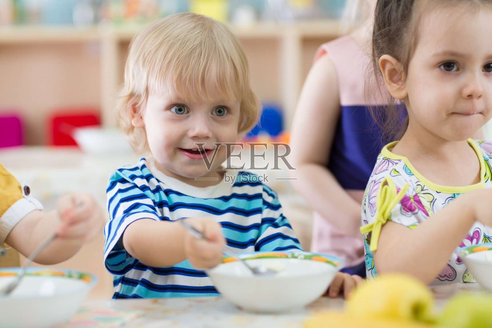 在日托中心吃盘子的孩子照片摄影图片